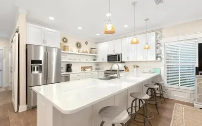 a kitchen with white cabinets and a stainless steel refrigerator at Casa De La Sirena by Oversee 30A in Seacrest