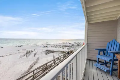 a porch with a blue chair and the beach at Leeward II Unit 4 by Oversee 30A in Santa Rosa Beach
