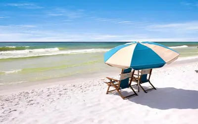 a chair and an umbrella on the beach at Leeward II Unit 4 by Oversee 30A in Santa Rosa Beach