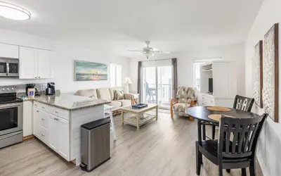 a kitchen and living room with a table and chairs at Leeward II Unit 4 by Oversee 30A in Santa Rosa Beach
