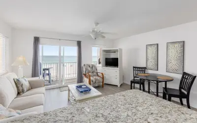 a living room with a couch and a tv and a table at Leeward II Unit 4 by Oversee 30A in Santa Rosa Beach