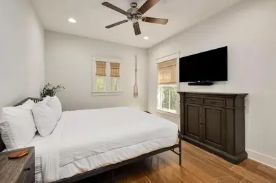 a bedroom with a bed and a flat screen tv at Naut 4 Sail by Oversee 30A in Seacrest