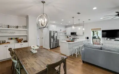 a kitchen and living room with a table and a couch at Naut 4 Sail by Oversee 30A in Seacrest