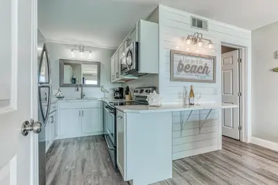 a kitchen with white cabinets and a counter top at -BeachFront Premium-Summit 1124 in Panama City Beach
