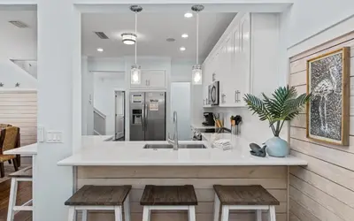 a kitchen with a island with wooden stools at Forever and Always by Oversee 30A in Seacrest