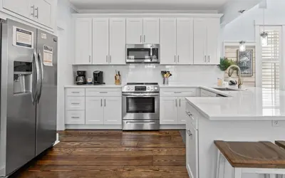 a kitchen with white cabinets and stainless steel appliances at Forever and Always by Oversee 30A in Seacrest