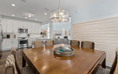 a kitchen and dining room with a wooden table and chairs at Forever and Always by Oversee 30A in Seacrest