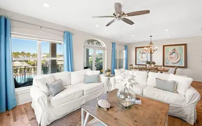 a living room with a white couch and a table at Oasis By The Water by Oversee 30A in Seacrest