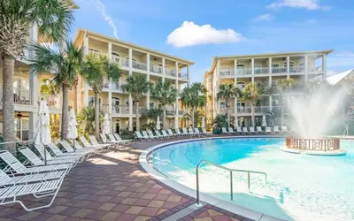 a resort with a swimming pool with chairs and a fountain at Oasis By The Water by Oversee 30A in Seacrest