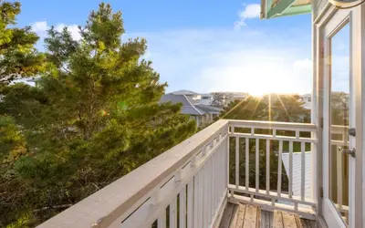 a balcony with a view of a house at The Loopy Crab by Oversee 30A in Seacrest