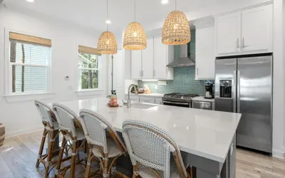 a kitchen with a large white island with chairs at Sweet Lu-Sea by Oversee 30A in Santa Rosa Beach