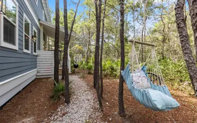 a blue hammock hanging in front of a house at Sweet Lu-Sea by Oversee 30A in Santa Rosa Beach