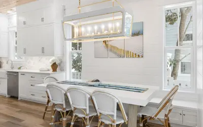 a white kitchen with a dining table and chairs at Good Times and Tan Lines by Oversee 30A in Santa Rosa Beach