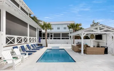 a patio with chairs and a swimming pool at Good Times and Tan Lines by Oversee 30A in Santa Rosa Beach