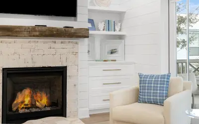 a living room with a fireplace with a tv above it at Good Times and Tan Lines by Oversee 30A in Santa Rosa Beach