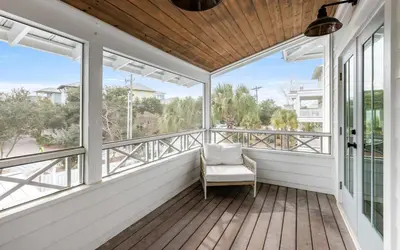 a porch with a chair on a wooden deck at Good Times and Tan Lines by Oversee 30A in Santa Rosa Beach