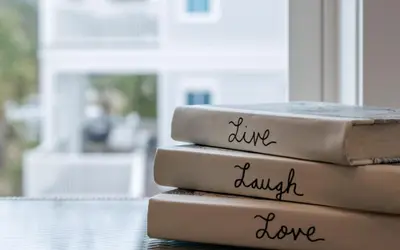 a stack of books sitting on top of a table at Good Times and Tan Lines by Oversee 30A in Santa Rosa Beach