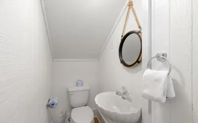 a bathroom with a sink and a toilet and a mirror at Gone Coastal by Oversee 30A in Santa Rosa Beach