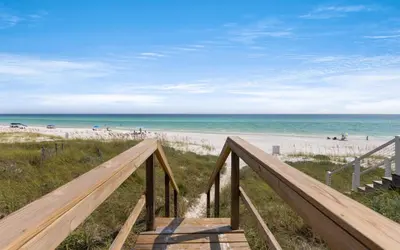 a stairway to the beach with people on the beach at Gone Coastal by Oversee 30A in Santa Rosa Beach