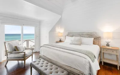 a white bedroom with a large bed and a chair at Gone Coastal by Oversee 30A in Santa Rosa Beach