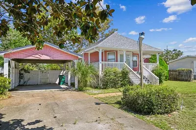 a red house with a garage in a yard at 2340 Grand Oaks Ln home in Panama City Beach
