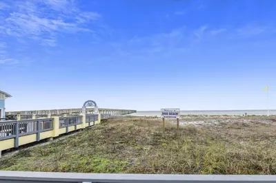 a beach with a sign in front of the ocean at 2340 Grand Oaks Ln home in Panama City Beach
