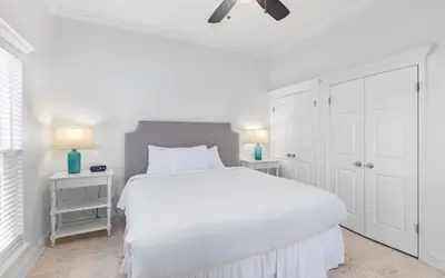 a white bedroom with a white bed and two night stands at Brothers Beach Bungalow by Oversee 30A in Santa Rosa Beach