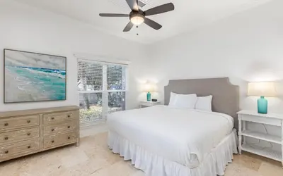 a bedroom with a white bed and a ceiling fan at Brothers Beach Bungalow by Oversee 30A in Santa Rosa Beach