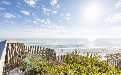 a beach with a wooden fence and the ocean at Brothers Beach Bungalow by Oversee 30A in Santa Rosa Beach