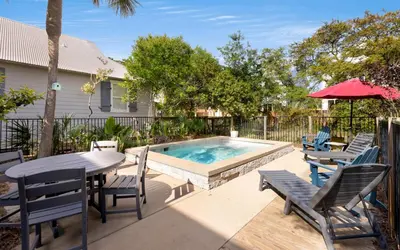 a patio with a table and chairs and a pool at Casa Playa by Oversee 30A in Santa Rosa Beach