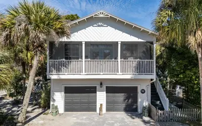 a house with a balcony and palm trees at Casa Playa by Oversee 30A in Santa Rosa Beach