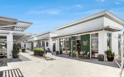a building with a patio with chairs and tables at Clareon By The Coast by Oversee 30A in Seacrest