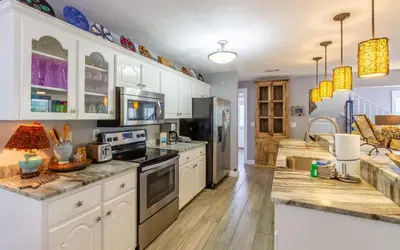 a kitchen with white cabinets and stainless steel appliances at Clareon By The Coast by Oversee 30A in Seacrest