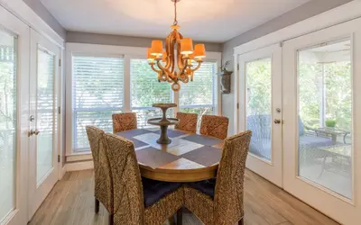 a dining room with a table and chairs and a chandelier at Clareon By The Coast by Oversee 30A in Seacrest