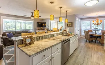 a kitchen with a sink and a living room at Clareon By The Coast by Oversee 30A in Seacrest