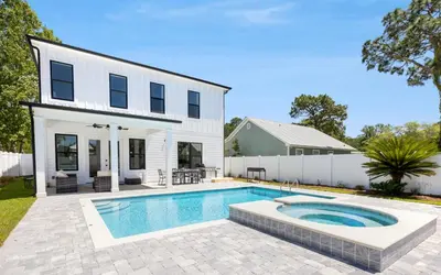 a house with a swimming pool in front of a house at Coconut Cove by Oversee 30A in Santa Rosa Beach