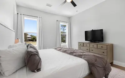 a bedroom with a bed and a tv on a dresser at Coconut Cove by Oversee 30A in Santa Rosa Beach