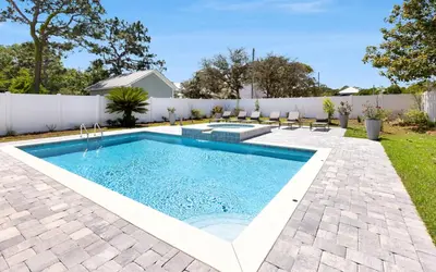 a swimming pool in a backyard with a white fence at Coconut Cove by Oversee 30A in Santa Rosa Beach