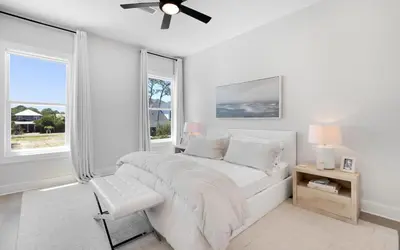 a white bedroom with a bed and windows at Coconut Cove by Oversee 30A in Santa Rosa Beach