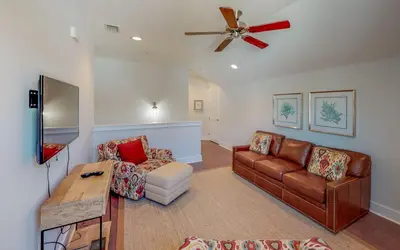 a living room with a couch and a ceiling fan at Coral Retreat by Oversee 30A in Seacrest