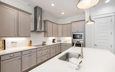 a kitchen with white cabinets and a sink at Coral Retreat by Oversee 30A in Seacrest