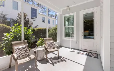 two chairs on the porch of a house at Coral Retreat by Oversee 30A in Seacrest