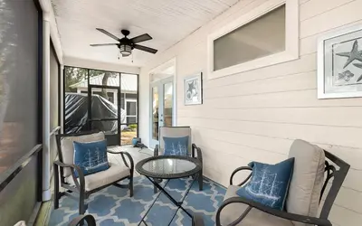 a porch with chairs and a table and a ceiling fan at Dare To Dream by Oversee 30A in Seacrest