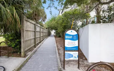 a sign on the side of a sidewalk next to a fence at Dare To Dream by Oversee 30A in Seacrest