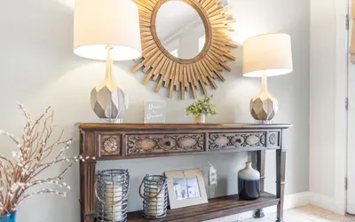 a console table with two lamps and a mirror at Dare To Dream by Oversee 30A in Seacrest