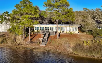 a house by the water with benches and trees at Easy Breezy by Oversee 30A in Santa Rosa Beach