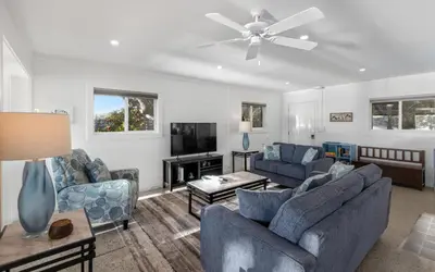 a living room with two blue couches and a tv at Easy Breezy by Oversee 30A in Santa Rosa Beach