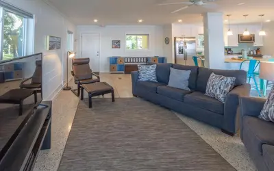 a living room with a blue couch and a kitchen at Easy Breezy by Oversee 30A in Santa Rosa Beach