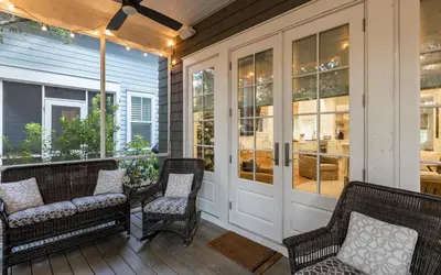 a screened porch with rocking chairs and glass doors at Emerald Tranquility by Oversee 30A in Santa Rosa Beach