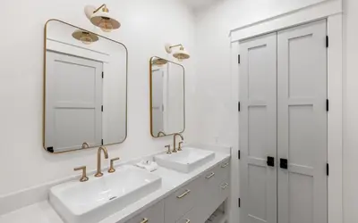 a white bathroom with two sinks and two mirrors at Emerald Tranquility by Oversee 30A in Santa Rosa Beach